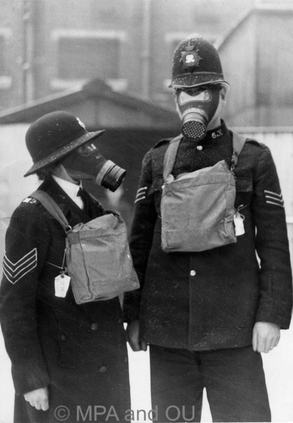 Police officers wearing gas masks
