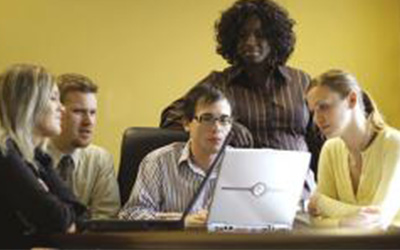 A group of people gathered around a laptop