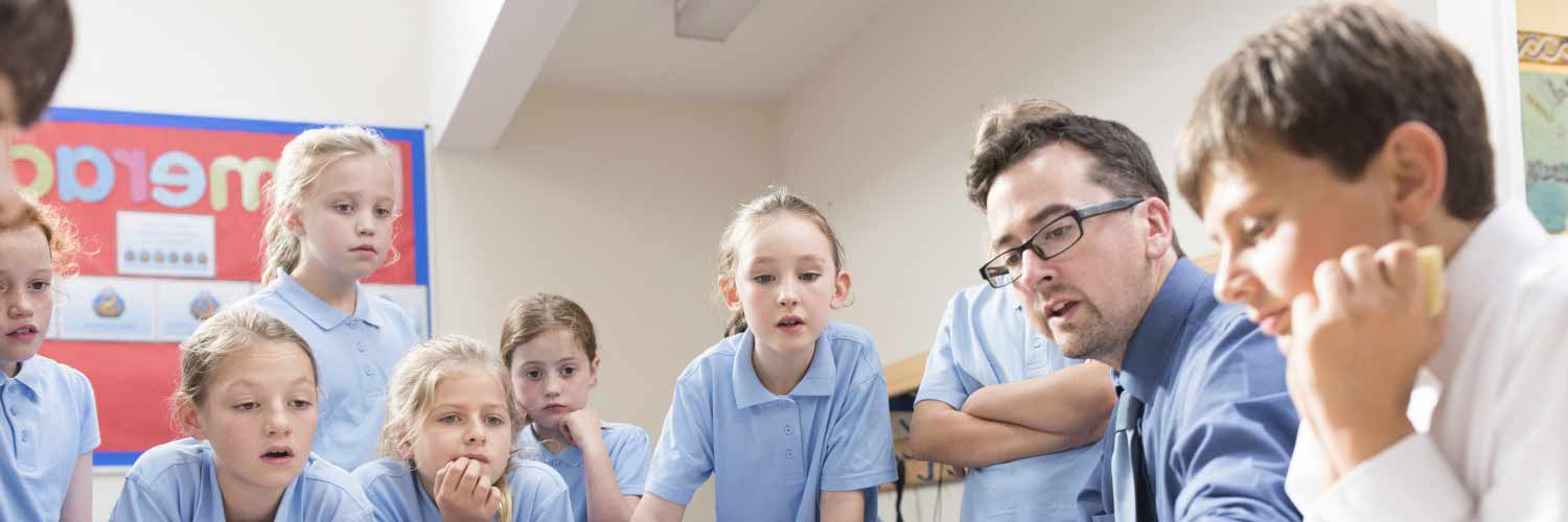 Children watching an experiment with Male teacher