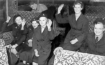 An old black and white photo of a group of girl guides in (what looks like) a railway carriage