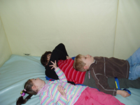 hree children playing on a bed