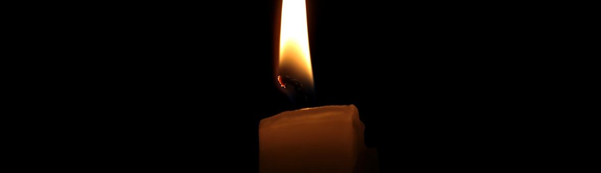 A lit candle in a dark room