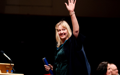 Rea waving to the crowd as she receives her certificate at the OU in Belfast degree ceremony