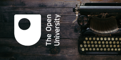 The Open University logo next to a typewriter on a wooden table