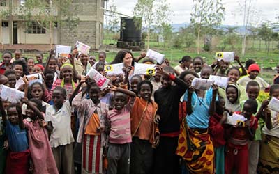 Maria Macnamara, founder of Smalls for All and OU Honorary Graduate, with children in Africa