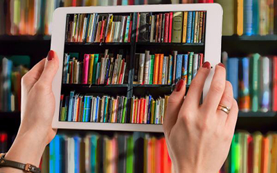 Person holding iPad with a view of books on its screen