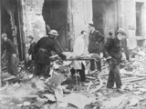 a woman being carried from a bombed building on a stretcher in London