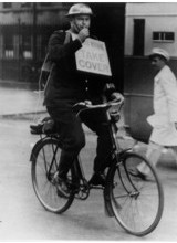 Take cover: a policeman on a bicycle issuing an air raid warning