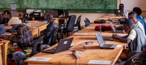 Adults work at laptops in an African classroom