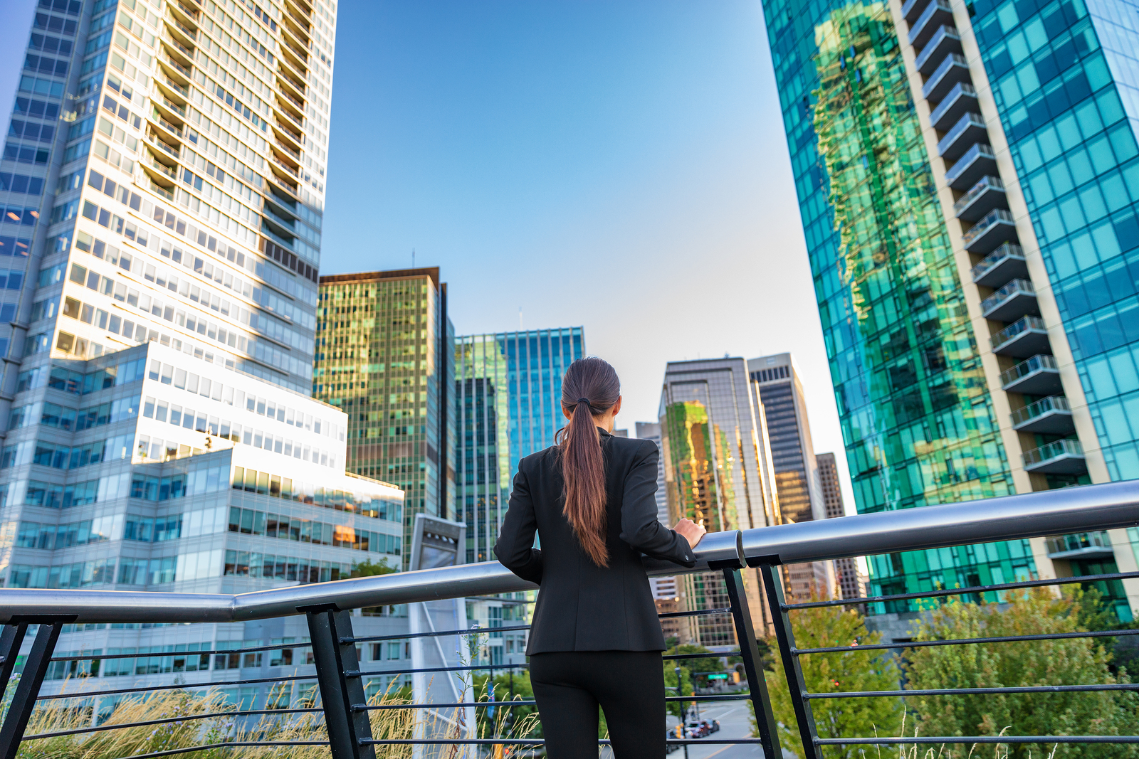 Business woman in city center looking at view of skyline skyscrapers.