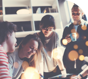 Photo of group of young people working together looking at desk