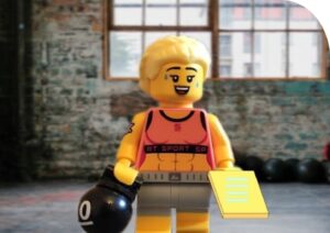 Image of Lego figure in workout clothes holding a weight.
