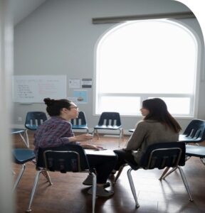 Photo of a counselling support group - two women sitting and talking.