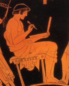 boy writing on a wax tablet, as shown on a Greek vase