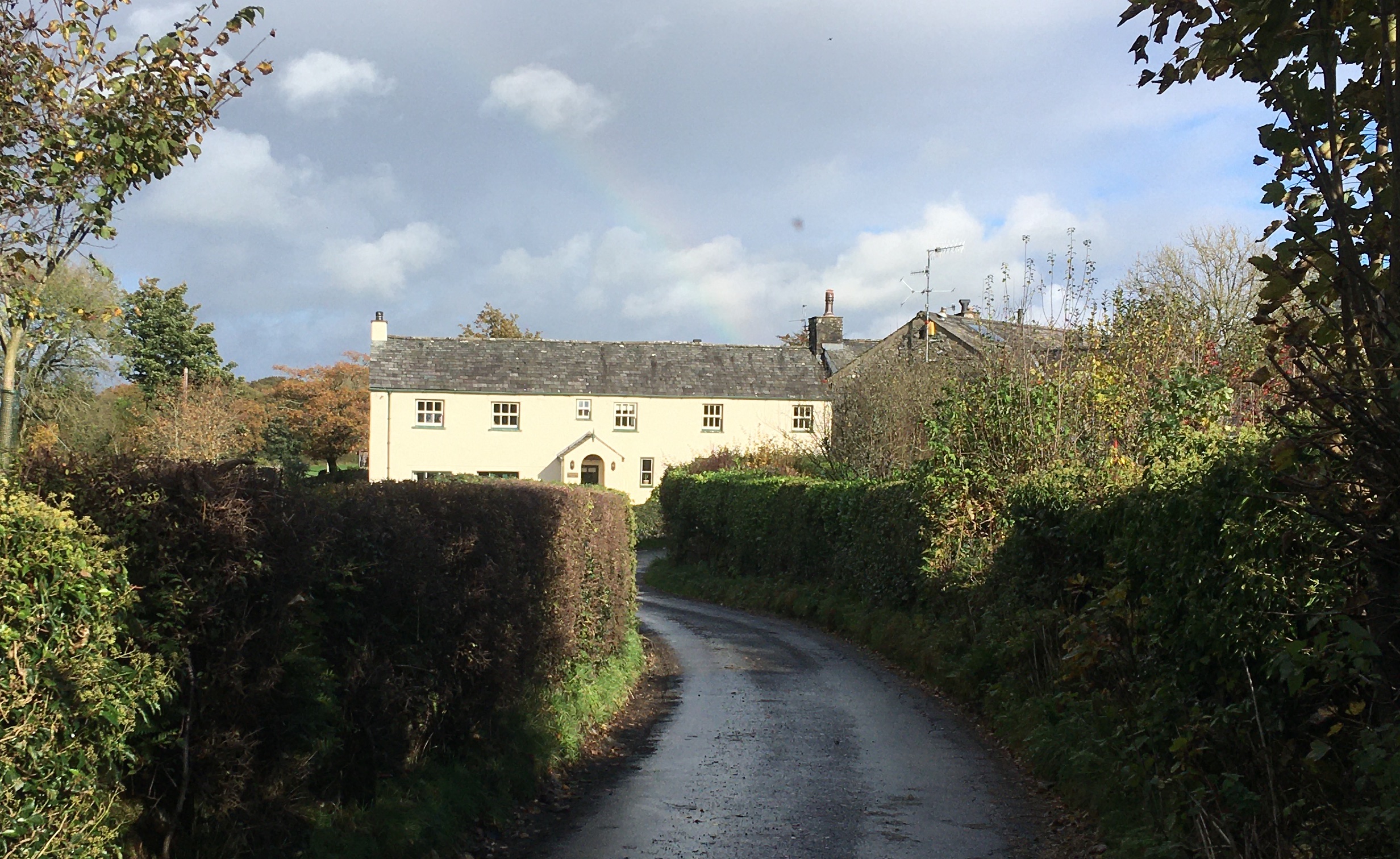 Rural house with rainbow above
