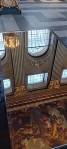 Mirror reflecting a painted ceiling