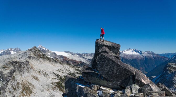 Image of mountaineer at the top of a mountain