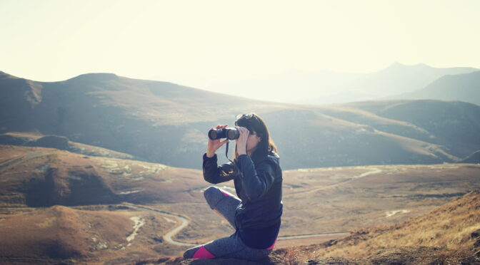 Image of hiker looking through binoculars