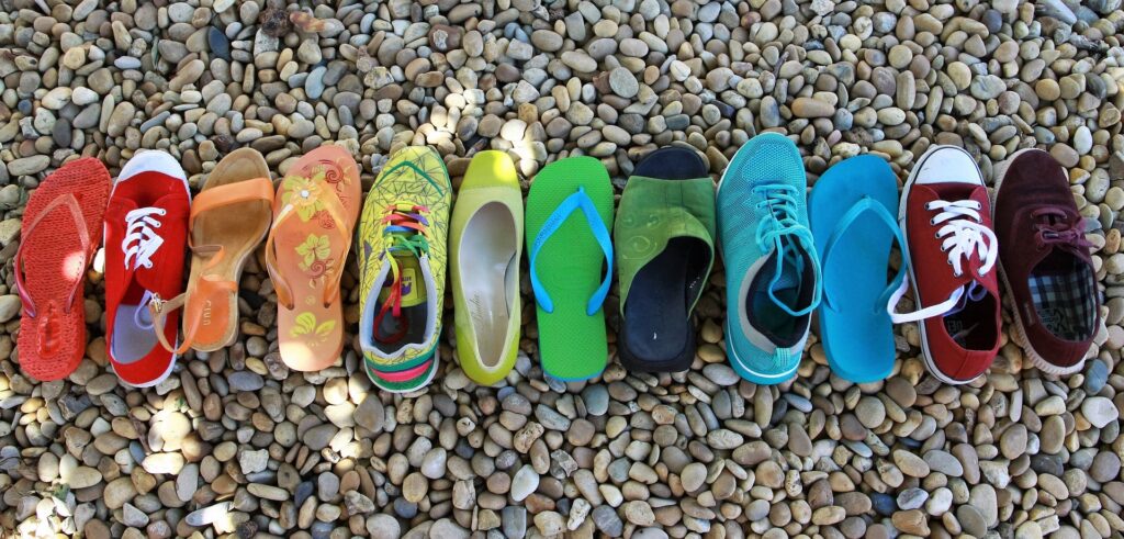 Photo of multi-coloured shoes on a beach
