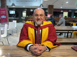Photograph of Andrew Maleknia in graduation gown