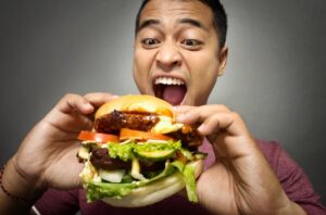 Man eating a huge burger