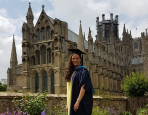 Emma Roache stood outside Ely Cathedral in her graduation robes