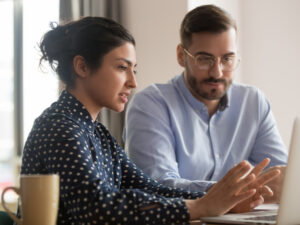 Man and woman working at laptop in business attire