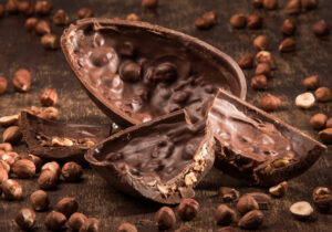 Stuffed chocolate easter egg on a wood table with hazelnuts