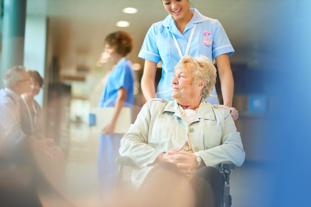 Female nurse pushing a patient in a wheelchair
