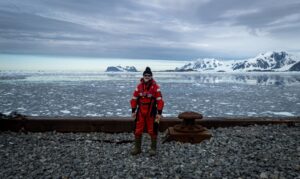 Andy dressed in warm clothing with a backdrop of Antarctica