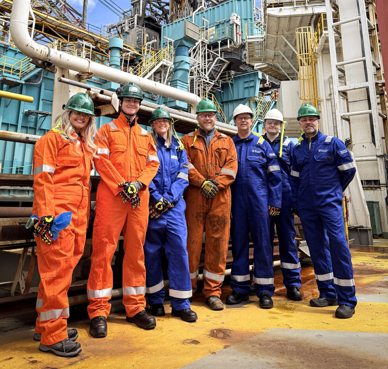 Open University Engineering student Callum and colleagues stand on an offshore oil rig in the North Sea