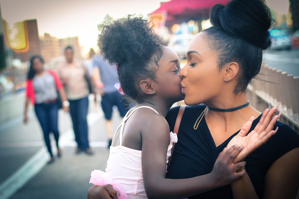 Image shows mother kissing her young daughter. Image credit: Pixabay