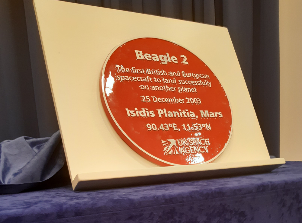 Close up image of the plaque about Beagle 2, in red with an inscription. Copyright the OU.
