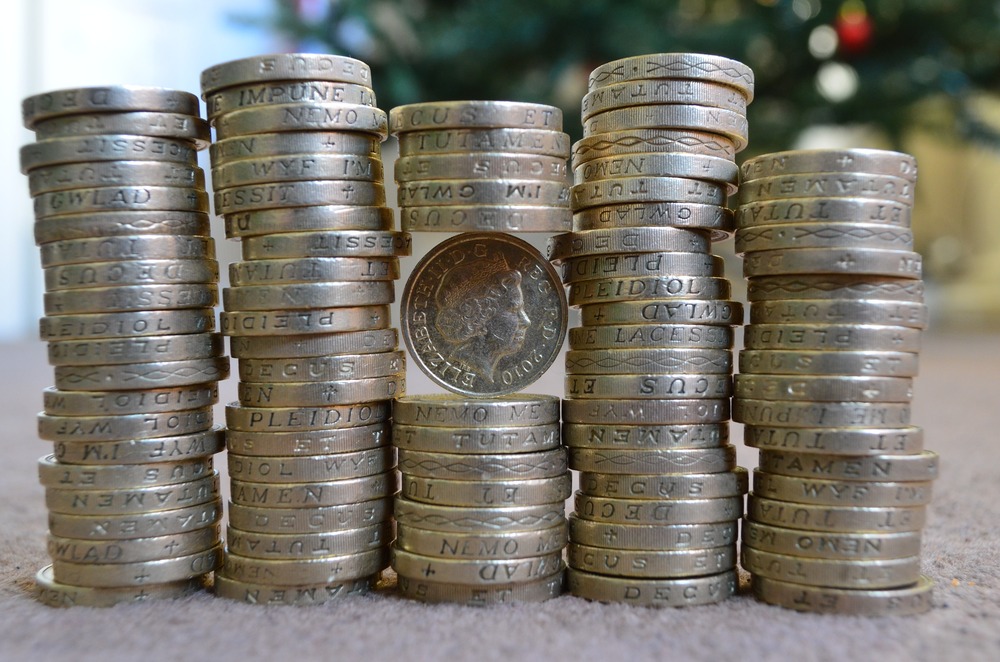 Stacks of one-pound coins with a single coin standing upright in the centre