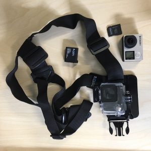 The Go Pro Kit, showing the camera, batteries and shoulder strap.
