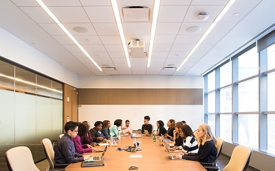 This photo shows a group of women who all work at Microsoft in a meeting around a table