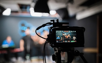 A live recording of an event is shown through the screen of a camera with the blurred subjects in the background