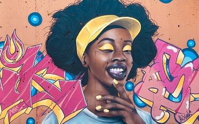 Stunning wall art of a beautiful Black woman winking at us with yellow eye shadow and a matching yellow hat