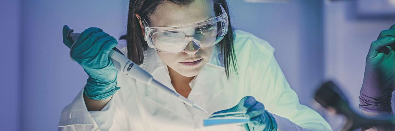 Female scientist taking a sample from a petri dish