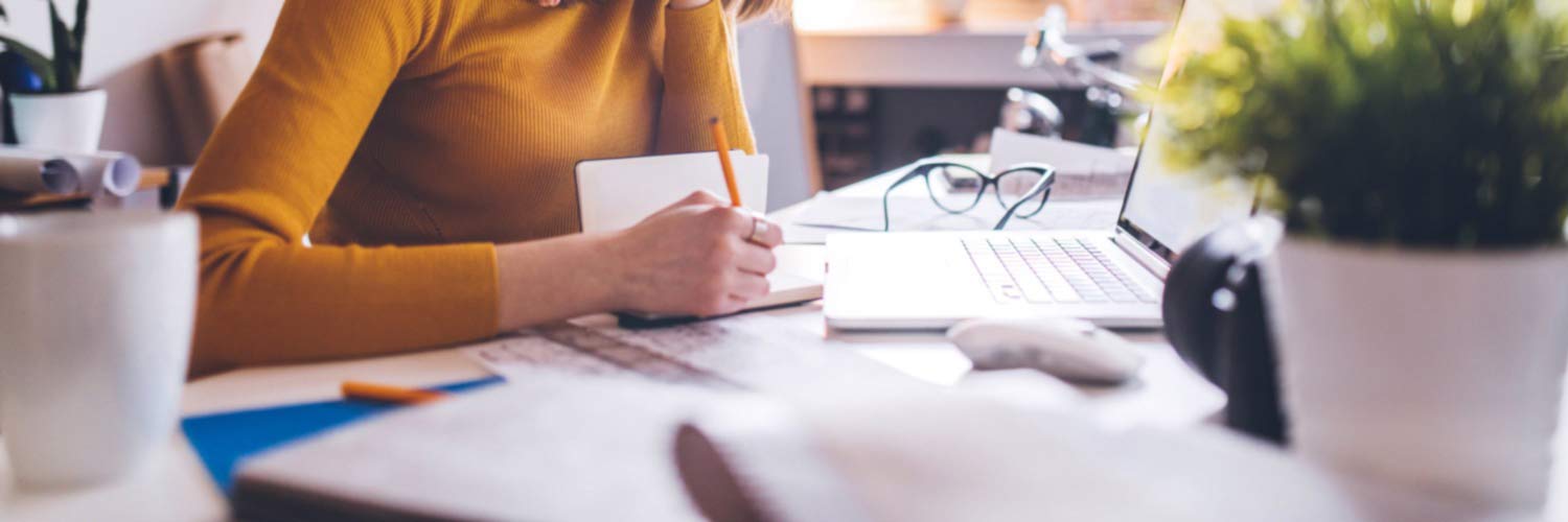 Woman making notes at her desk