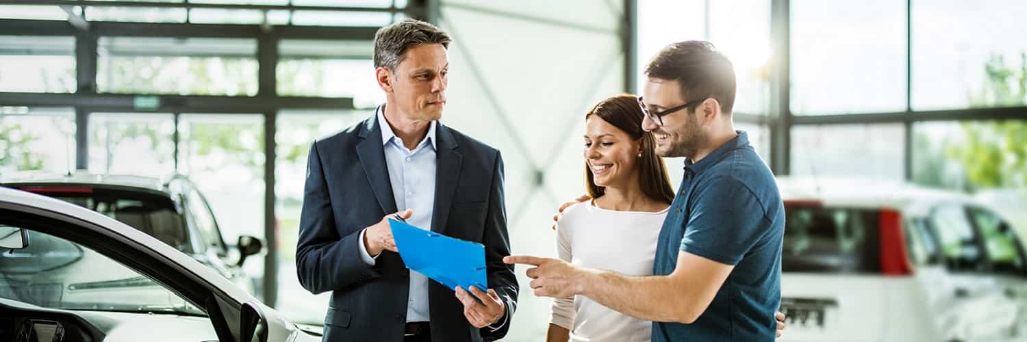 Couple buying a new car in a dealership