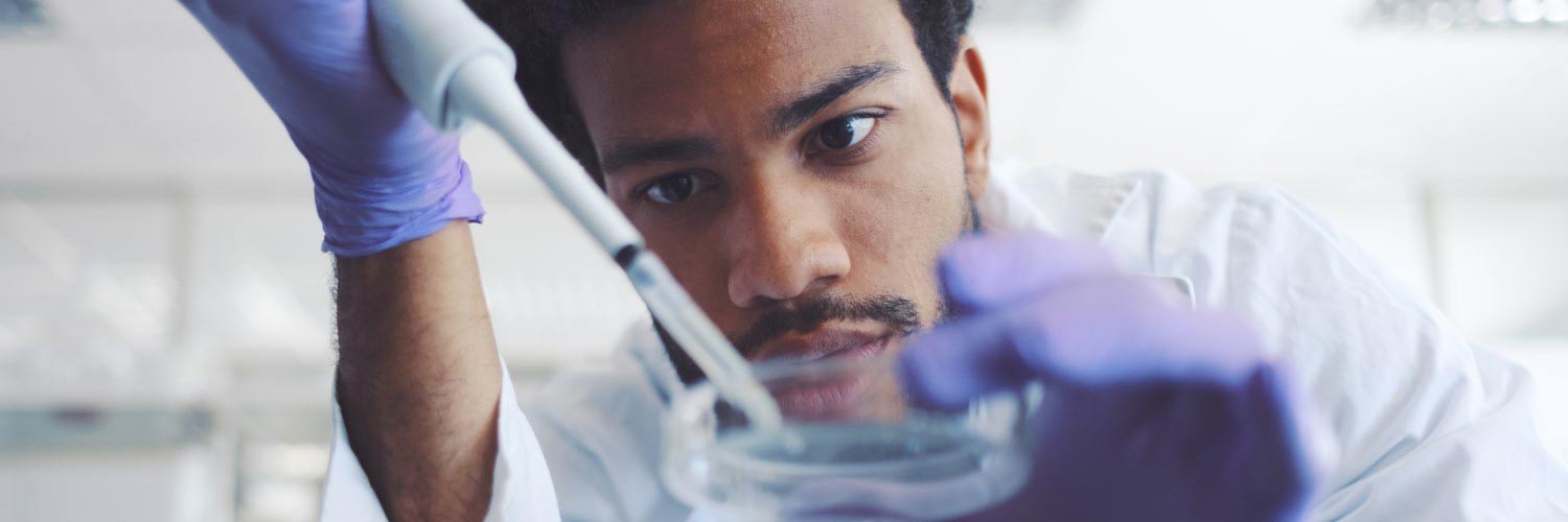 Chemistry diploma graduate using syringe and petri dish