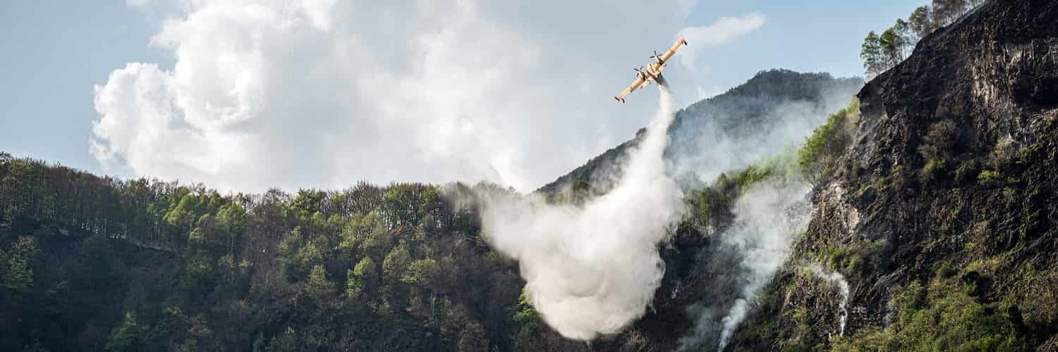 Plane dropping water to put out forest fire