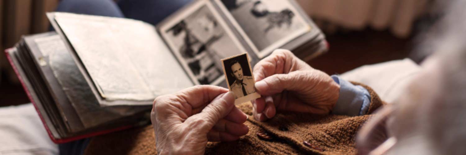 Elderly person looking at an album of historical photos