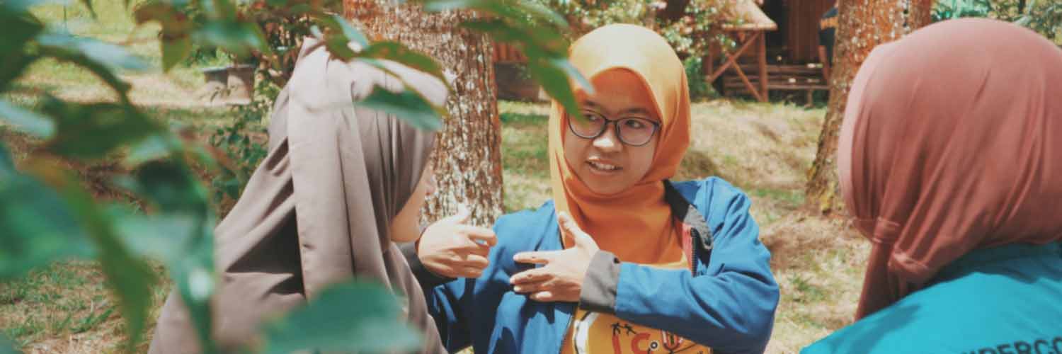 Three young women in headscarves having a conversation outside