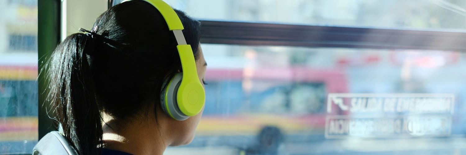 Young woman with headphones on a bus in Spain