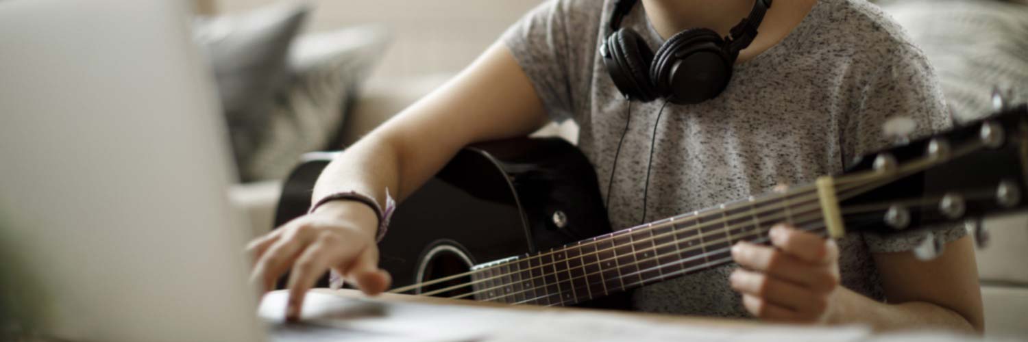 Female musician with guitar and laptop