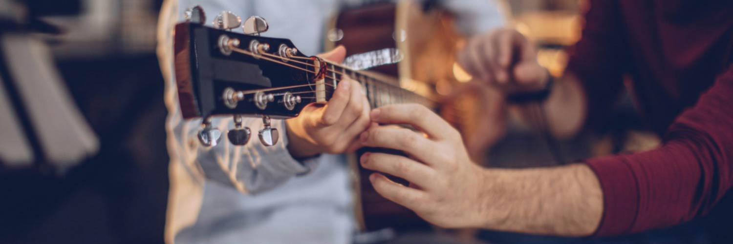 Music teacher giving guitar lesson