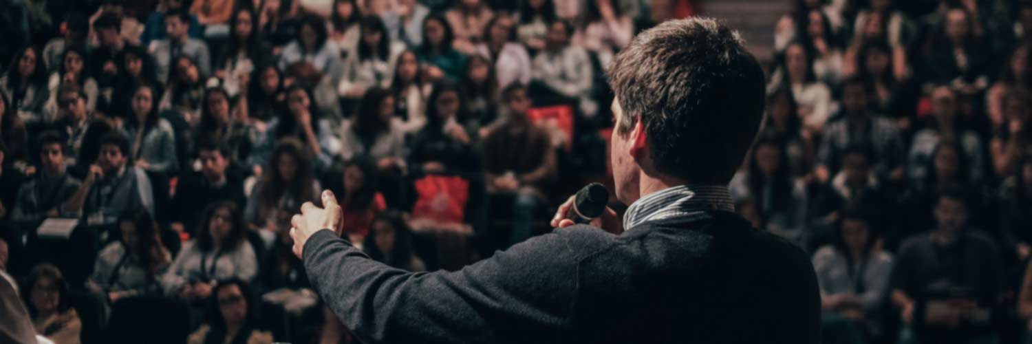 Speaker addressing a crowd at a large meeting or rally