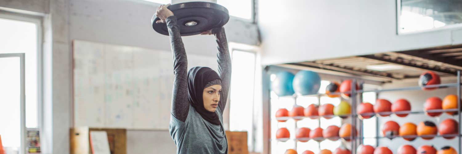 Female wearing hijab working out with weights